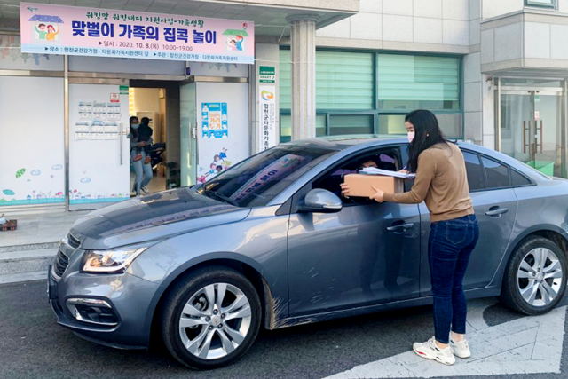 합천군 관계자가 맞벌이 30가정에 젤리곰 비누 만들기와 버섯 키우기 체험키트를 드라이브 스루 방식으로 배부하고 있습니다