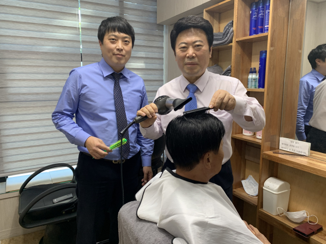대한민국 가발업계 명장 1호 최원희 최원프리모 대표가 대구 서구 내당동 매장에서 손님의 가발을 손질하고 있다. 왼쪽은 가업을 잇고 있는 최 대표 아들 최이명 부장. 김윤기 기자