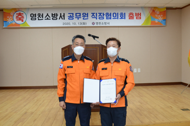 김재훈 영천소방서장이 조수경(오른쪽) 초대 직장협의회장에게 설립증을 교부하며 공무원 직장협의회 출범을 축하하고 있다. 영천소방서 제공
