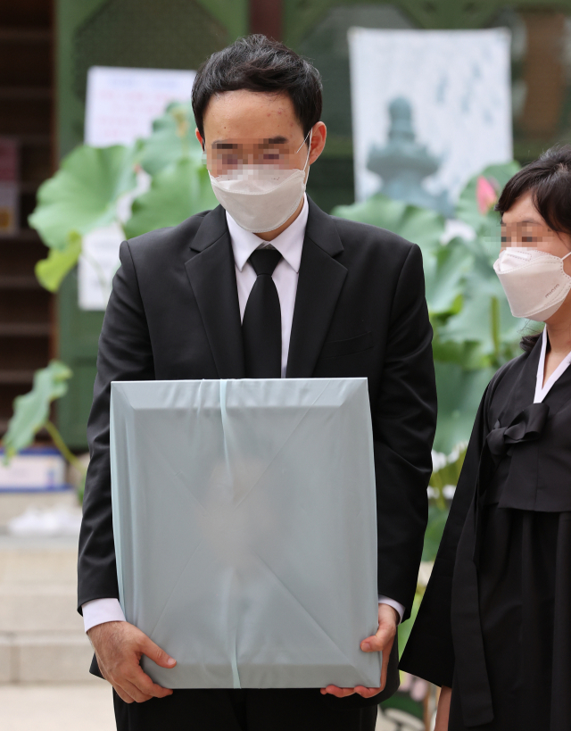 고 박원순 서울시장의 아들인 박주신 씨와 가족이 서울 종로구 조계사에서 박 시장의 49재를 마친 뒤 아버지의 영정을 들고 추모객과 인사하고 있다. 연합뉴스
