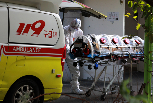 지난 14일 오전 부산 북구 만덕동 해뜨락 요양병원에서 코로나19 환자 이송이 진행되고 있다. 연합뉴스