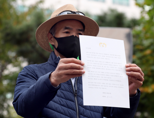 서해 북단 소연평도 해상에서 실종됐다가 북한군에 사살된 해양수산부 공무원의 형 이래진씨가 14일 오후 인천시 연수구 해양경찰청 앞에서 기자회견을 하던 중 문재인 대통령으로부터 받은 편지를 공개하고 있다. 연합뉴스
