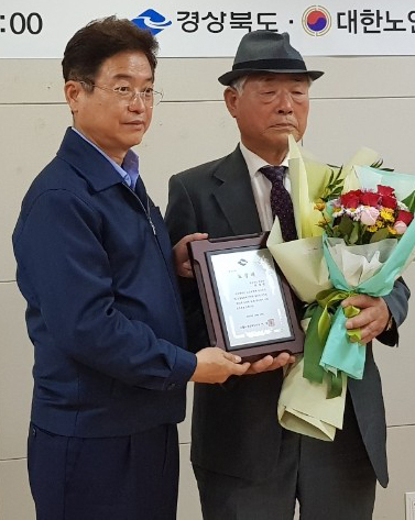 최재림(오른쪽) 대한노인회 경산 하양분회경로당 분회장이 15일 제24회 노인의 날 기념행사에서 모범노인으로 선정돼 경북도지사 표창을 수상했다,