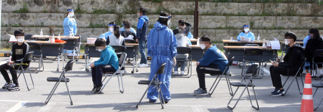 지난 13일 강원 강릉시보건소 선별진료소에서 강릉 시내 중학생이 코로나19 검사를 기다리고 있다. 연합뉴스