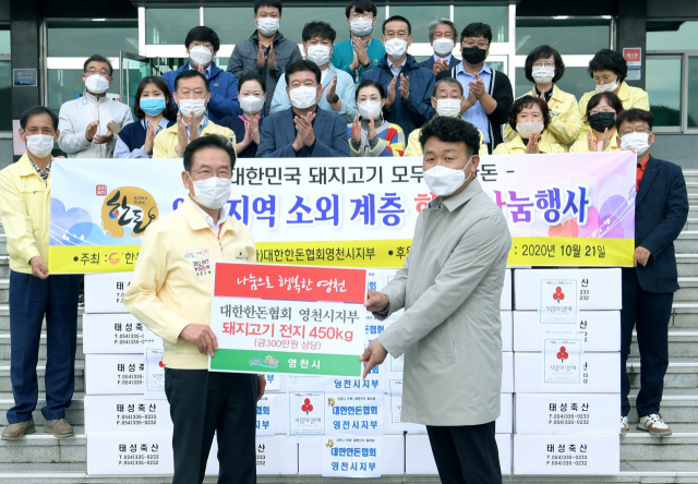 대한한돈협회 영천시지부가 영천시에 지역 소외계층을 위한 돼지고기와 함께 장학금을 전달하고 있다. 영천시 제공