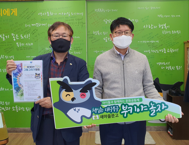 매년 책 선물 릴레이 퍼포먼스에 참여하고 있는 배광식(오른쪽) 북구청장이 14일 이승로 회장과 함께 포즈를 취하고 있다. 새마을문고중앙회 대구시북구지회 제공