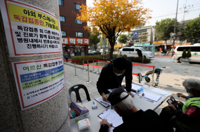 27일 서울 시내 한 병원을 찾은 내원객들이 인플루엔자(독감) 백신 예방 접종을 위해 문진표를 작성하고 있다. 연합뉴스