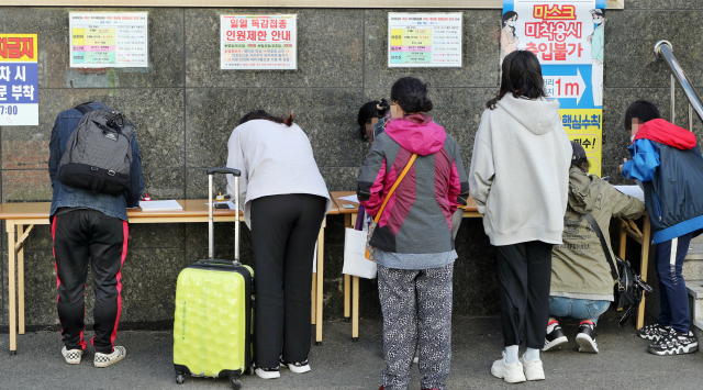 지난 24일 독감 예방접종을 위해 대구 한 의원을 찾은 시민들이 예진표를 작성하고 있다. 성일권 기자 sungig@imaeil.com