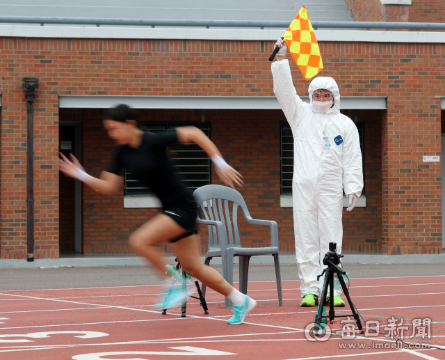 6일 계명대학교 성서캠퍼스에서 열린 2021학년도 수시모집 체육대학 실기고사 100m 달리기에서 방호복을 착용한 감독관이 수험생에게 출발 신호를 보내고 있다. 학교측은 수험생이 마스크를 벗고 달리기 때문에 코로나19 예방을 위해 감독관과 관리요원들에게 보호장비를 착용하도록 했다. 성일권 기자 sungig@imaeil.com
