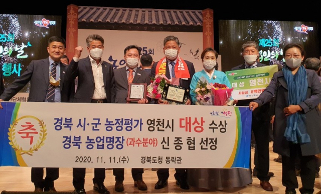제25회 농업인의 날 기념행사 및 경상북도 시․군 농정평가 시상식에서 대상을 받은 영천시 공무원들과 농업명장으로 선정된 신종협(오른쪽 네 번째) 씨가 수상을 축하하고 있다. 영천시 제공