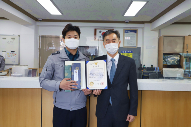 구미경찰서 상림지구대 권기훈(왼쪽) 경장이 이재영 경찰청 범죄예방정책과장으로부터 경찰청장 표창장을 받고 있다. 구미경찰서 제공