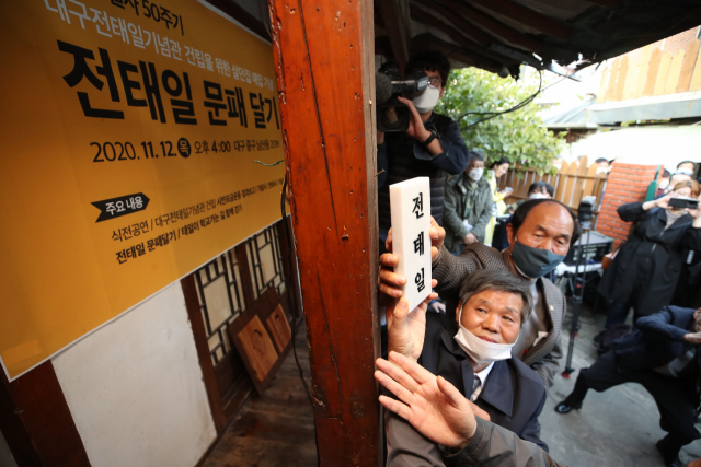 12일 오후 대구 중구 남산동 고(故) 전태일 열사의 옛집에서 유족 등이 문패를 달고 있다. 전 열사가 살았던 이 집은 사단법인 