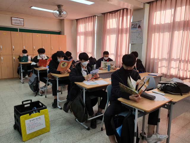 대구일마이스터고등학교가 다양한 방법으로 독서 문화 활성화에 나서 화제다. 이곳 학생들이 그림책 읽기와 연계한 체험활동을 하기 위해 그림책을 읽고 있는 모습. 대구일마이스터고 제공