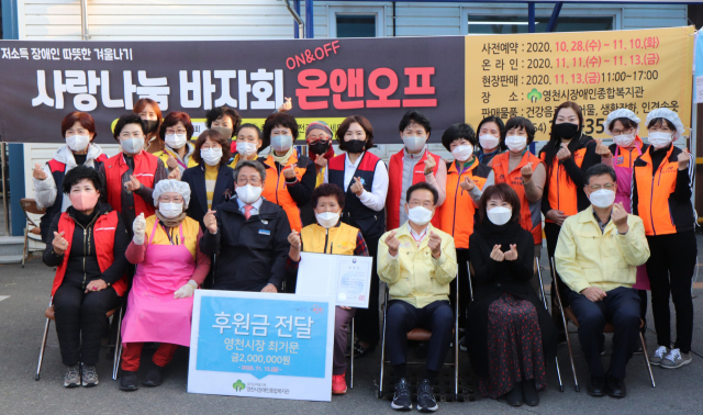 영천시장애인종합복지관에서 온.오프라인으로 진행한 사랑나눔 바자회 참여 자원봉사자들이 최기문 영천시장, 박홍열 관장 등과 기념촬영을 하고 있다. 영천시장애인종합복지관 제공