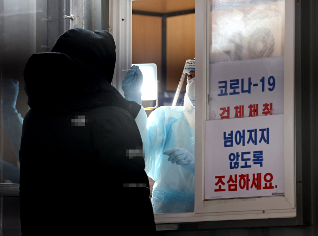 지난 17일 오후 서울 성동구보건소에 마련된 선별진료소에서 의료진이 검체를 채취하고 있다. 연합뉴스