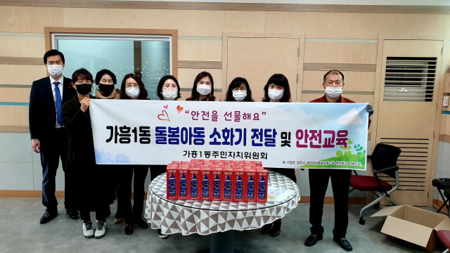 가흥1동 주민자치위원들이 소화기를 전달하고 있다. 영주시 제공