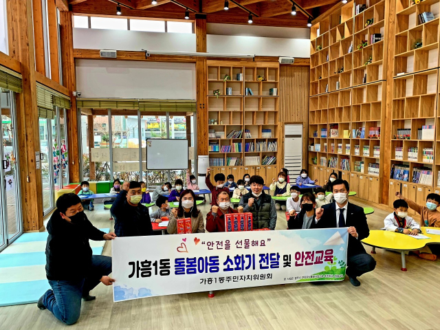 돌봄센터를 방문한 영주 가흥1동 주민자치위원들이 아이들과 기념사진을 촬영했다. 영주시 제공