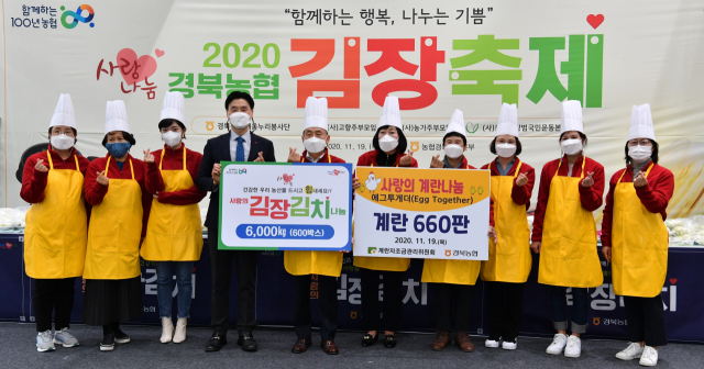 경북농협은 19일 김장대축제를 열어 김장김치 600박스, 계란 660판을 지역 소외계층에 전달했다. 전달식 참석자들이 기념촬영을 하는 모습. 경북농협 제공