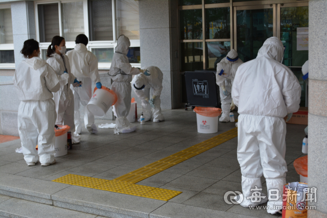 경산시보건소 직원들이 19일 오전 코로나19 확진자가 발생한 경산의 한 중학교에서 학생과 교직원들의 검체를 한 후 복도에서 의료폐기물을 정리하고 있다. 김진만 기자