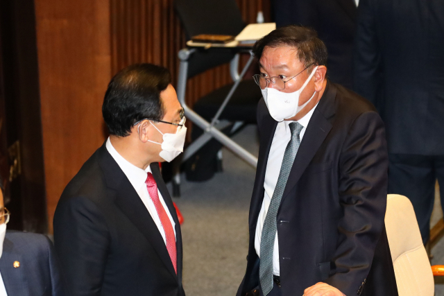 더불어민주당 김태년 원내대표(오른쪽)와 국민의힘 주호영 원내대표가 19일 서울 여의도 국회에서 열린 본회의에서 대화하고 있다. 연합뉴스