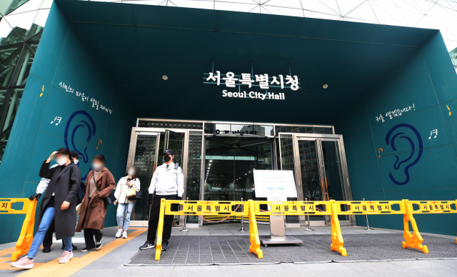 20일 오후 신종 코로나바이러스 감염증(코로나19) 확진자가 발생해 폐쇄된 서울시청 본관에서 직원들이 귀가하고 있다. 연합뉴스