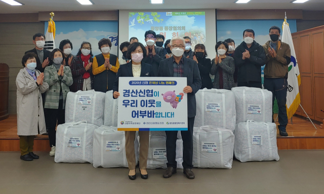 경산신협 이상수 이사장(앞줄 오른쪽)이 경산시 중앙동행정복지센터를 찾아 취약계층 이웃들을 위해 겨울 이불 22채를 기탁했다.