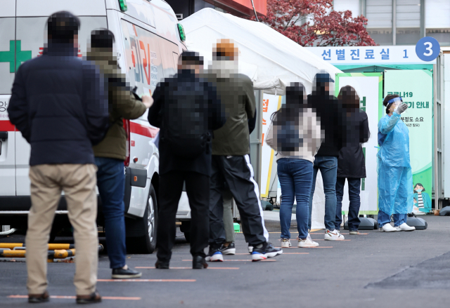 지난 23일 오전 서울 중구 국립중앙의료원에 마련된 선별진료소에서 시민들이 검사를 받기 위해 줄을 서 있다. 연합뉴스
