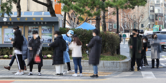 최근 노량진 학원 집단감염 등 코로나19 확진환자가 증가하는 가운데 25일 동작구청 주차장에 설치된 선별진료소 앞에서 시민들이 검사를 기다리고 있다. 연합뉴스