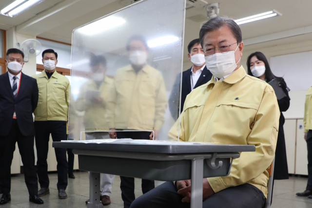문재인 대통령이 2021학년도 대학수학능력시험을 나흘 앞둔 29일 오후 자가격리 수험생을 위한 별도시험장이 마련된 서울 용산구 오산고등학교를 방문, 수험생 자리에 직접 앉아 시험장 칸막이 이격 거리를 살펴보는 등 방역 준비 상황을 점검하고 있다. 연합뉴스