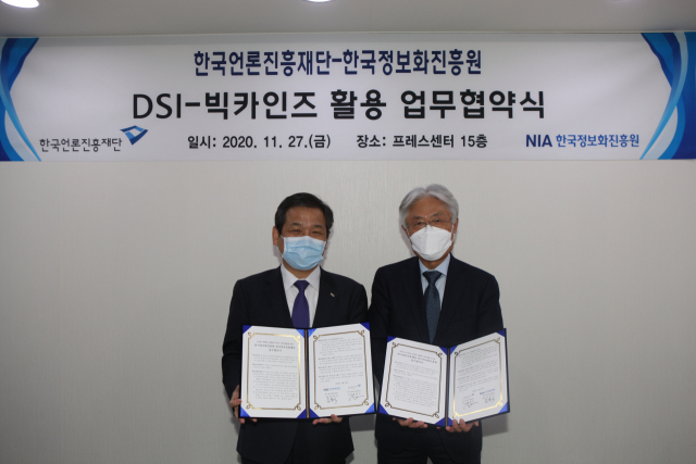 표완수(오른쪽) 한국언론진흥재단 이사장과 문용식 한국정보화진흥원 원장이 업무협약서에 서명하고 기념사진을 촬영하고 있다. 한국언론진흥재단 제공