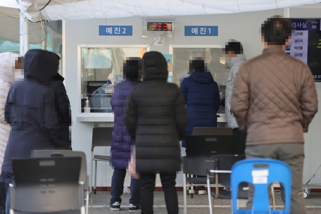 지난 30일 오후 서울 강동구보건소에 마련된 선별진료소에서 검사 대기자들이 줄을 서 있다. 연합뉴스