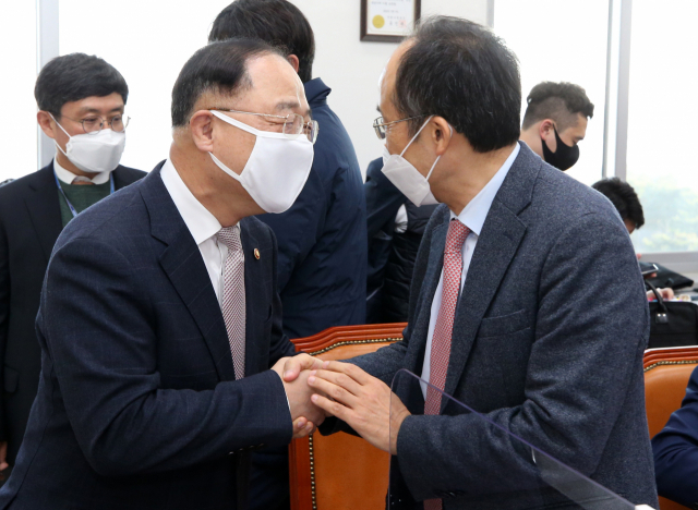 홍남기 경제부총리 겸 기획재정부 장관(왼쪽)이 23일 오전 서울 여의도 국회에서 열린 예산결산특별위원회 예산안등조정소위원회 회의에 인사차 방문, 국민의힘 추경호 간사와 인사하고 있다. 연합뉴스