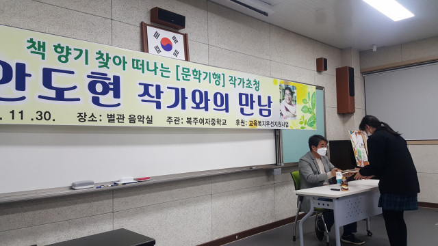 지난달 30일 경북 안동 복주여자중학교를 방문해 학생들과 소통의 시간을 가졌다. 사진은 학생들에게 사인을 해주고 있는 안 시인의 모습. 안동교육지원청 제공