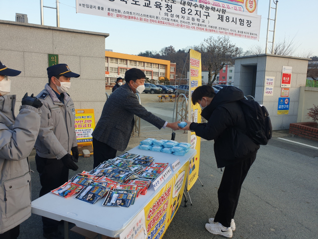 채경덕 경북 의성경찰서장이 의성여고 정문 앞에서 수험생들에게 손난로를 나눠주며 응원하고 있다. 의성경찰서 제공