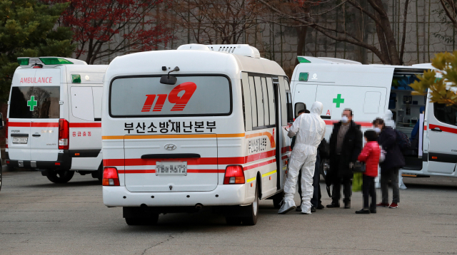 1일 오후 부산 연제구 한 주차장에서 코로나19 환자들이 대구 동산병원으로 이송되고 있다. 부산은 최근 코로나19 환자 급증으로 병상 운용에 어려움을 겪고 있다. 이날 확진 환자 중 경남 거주자 2명은 마산의료원으로, 36명은 대구동산병원으로 입원할 계획이다. 연합뉴스