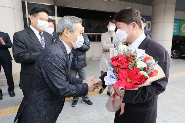 위암 수술을 받은 후 건강을 회복한 권영진(오른쪽) 대구시장이 7일 오전 18일만에 대구시청으로 출근하며 채홍호 행정부시장에게 꽃다발을 받고 있다. 김영진 기자 kyjmaeil@imaeil.com