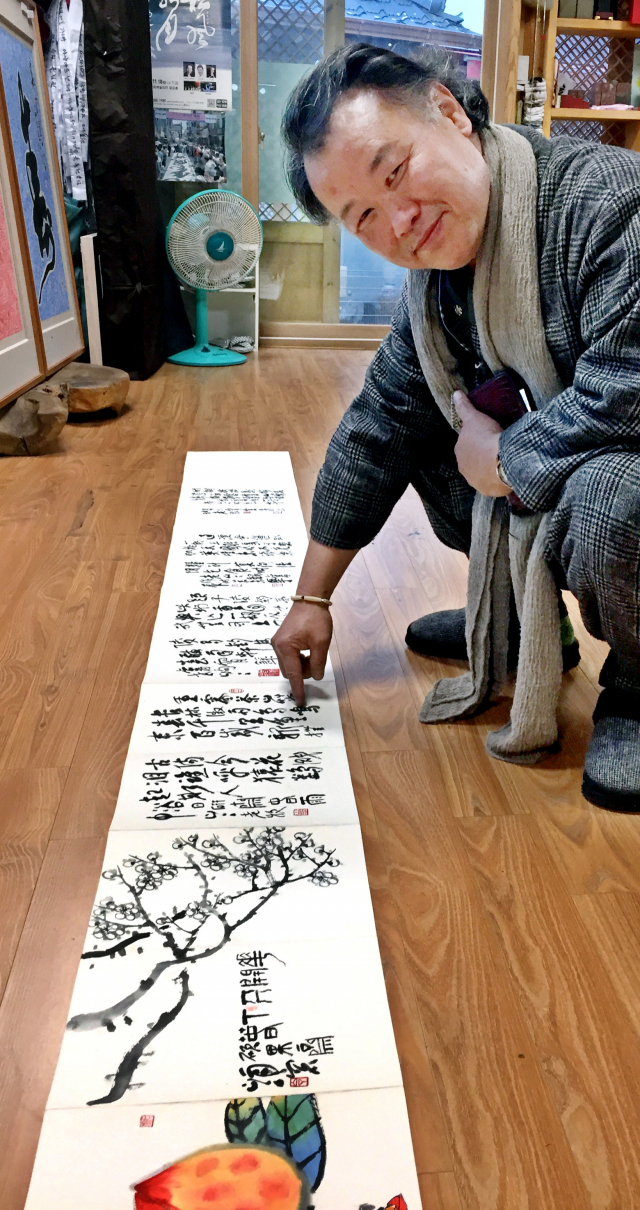 리홍재 서예가가 9일 자신의 서실에서 고 산정 서세옥 선생의 미발표 서화집을 펼쳐놓고 한시를 설명하고 있다.