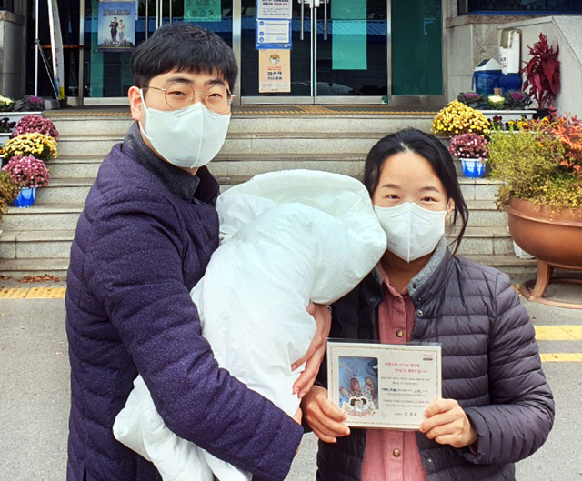 자녀의 출생신고와 함께 액자형 출생 축하카드를 받은 부모들이 환한 미소를 짓고 있다. 달성군 제공