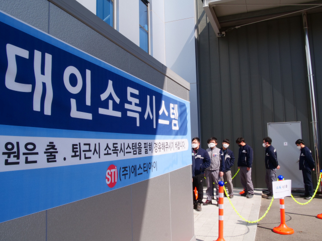 대구 성서5차산업단지 소재 광섬유소재제조사 STI 직원들이 자사에서 개발한 코로나19 방역용 대인소독기를 통과하기 위해 줄을 서 있다. 매일신문DB