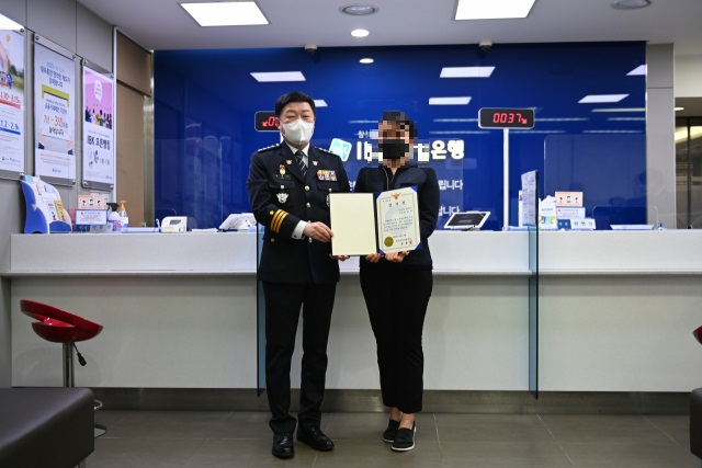 포항북부경찰서가 10일 포항시 북구 남빈동 기업은행 포항지점에서 보이스피싱 검거에 기여한 여직원에게 감사장을 전달하고 있다. 포항북부경찰서 제공.