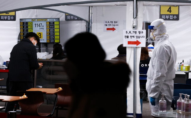 13일 오후 서울 강남구 보건소 선별진료소를 찾은 시민들이 신종 코로나바이러스 감염증(코로나19) 검체 채취를 위해 문진표를 작성한 뒤 차례를 기다리고 있다. 연합뉴스