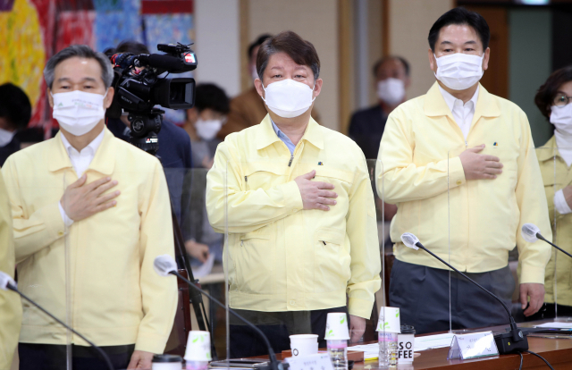 2일 오전 대구시청에서 열린 국민의힘·대구시 예산정책협의회에서 권영진 대구시장(가운데)과 대구시 관계자들이 국기에 경례하고 있다. 연합뉴스