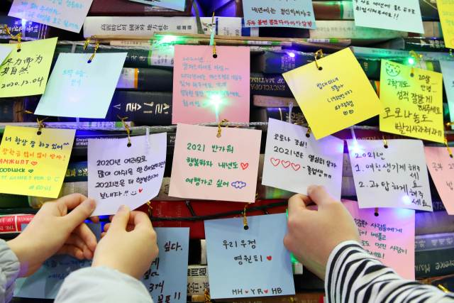 지난 8일 오후 경북 경산시 대구대학교 창파도서관에서 책으로 쌓은 크리스마스트리에 학생들이 남긴 새해 소망에 여행 가고 싶다는 내용이 들어 있다. 학교 측은 지난 2008년부터 폐기할 도서로 크리스마스트리를 만들어 학생들이 소망을 붙일 수 있게 했다. 올해는 3천 권의 책을 이용해 높이 4m, 폭 3m의 트리를 만들었다. 연합뉴스