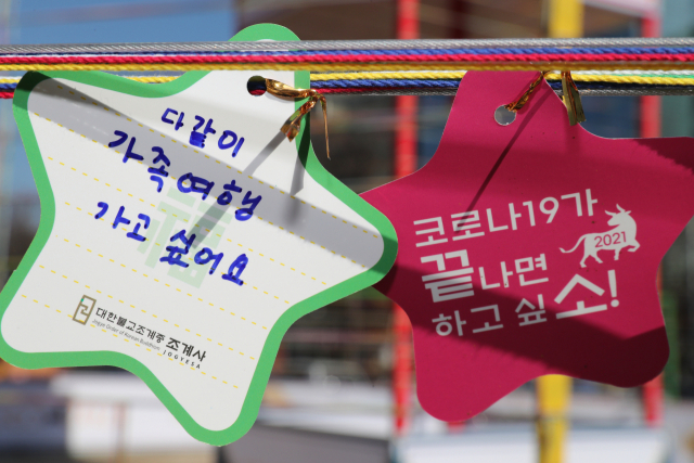 지난 1일 서울시 종로구 조계사 소원의 탑에 한 어린이집 아이들이 붙인 소원지에 가족 여행 가고 싶다는 내용 등이 들어 있다. 연합뉴스