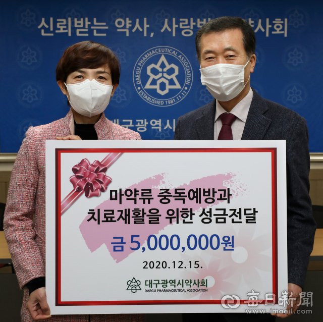 조용일 대구시약사회장(오른쪽)이 15일 수성구 황금동 대구시약사회관에서 이향이 대구마약퇴치운동본부장에게 마약류 중독예방과 치료재활을 위한 사업에 써 달라며 성금 500만원을 전달하고 있다. 정운철 기자 woon@imaeil.com