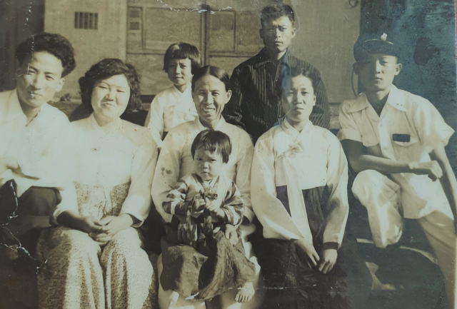 1950년대쯤 색동 한복을 입은 채 할머니에게 안겨 있는 김경희(가운데) 씨와 검은색 줄무늬 셔츠를 입은 아버지 김해근(뒷줄) 씨, 한복을 입은 어머니 김복순(오른쪽 두번째) 씨 등이 찍은 가족사진. 가족제공.