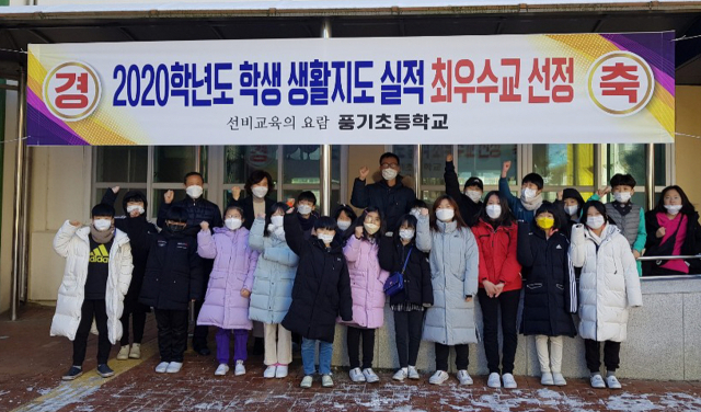 학생생활 최우수교로 선정된 풍기초 교사와 학생들이 파이팅을 외치고 있다. 풍기초 제공