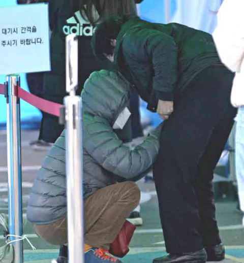 지난달 16일 오후 대구 수성구보건소에서 한 시민이 코로나19 선별검사를 받기위해 차례를 기다리던 중 노모의 옷매무새를 고쳐주고 있다. 김영진 기자 kyjmaeil@imaeil.com