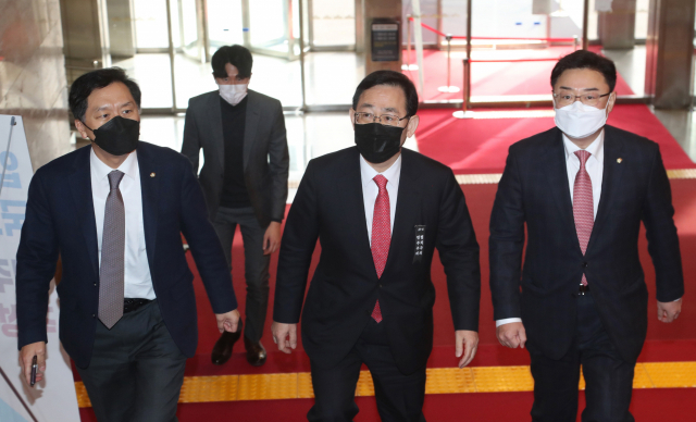 원내대표 사퇴 의사를 밝힌 국민의힘 주호영 원내대표가 18일 국회에서 열린 의원총회에서 의원들의 재신임을 받은 뒤 다시 의원총회장으로 향하고 있다. 왼쪽부터 김기현 의원, 주 원내대표, 김성원 원내수석부대표. 연합뉴스