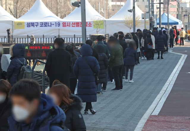 18일 오후 서울 성북구청 앞 임시 선별진료소에서 시민들이 코로나19 검사를 받기 위해 차례를 기다리고 있다. 서울 성북구는 구청 직원 1명이 코로나19 확진 판정을 받아 청사를 오는 20일까지 임시 폐쇄한다. 연합뉴스